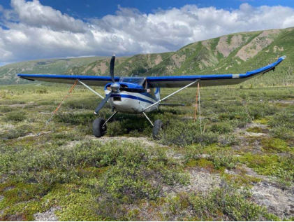 Photograph 1 – View of the airplane and damage to left wing., from the NTSB investigation of Cessna 180H accident near Gulkana, Alaska, July 17, 2025