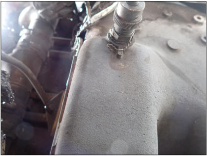 Photograph 5 – Oil quick drain as found at accident site, from the NTSB investigation of Beech V35A accident near Arvada, Colorado, June 7, 2024