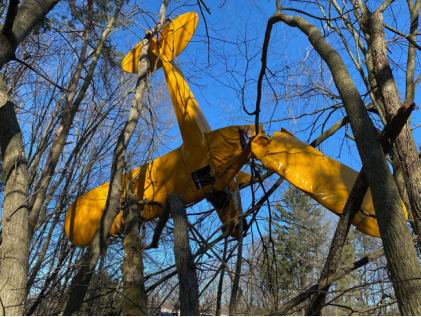 Photograph 2 – Damaged left wing and vertical stabilizer, from the NTSB investigation of Piper J3C-65 accident near South Lyon, Michigan, February 12, 2024