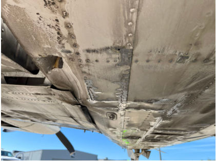 Photograph 2 – Lower Fuselage and Wing Damage, from the NTSB investigation of Beech 58 accident near Kalamazoo, Michigan, August 6, 2024