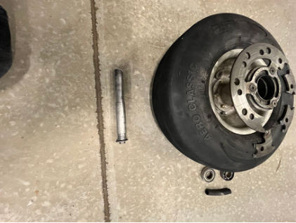 Photograph 3 – Separated Left Wheel Assembly, from the NTSB investigation of Amateur-built VM1 accident near Oshkosh, Wisconsin, August 27, 2024