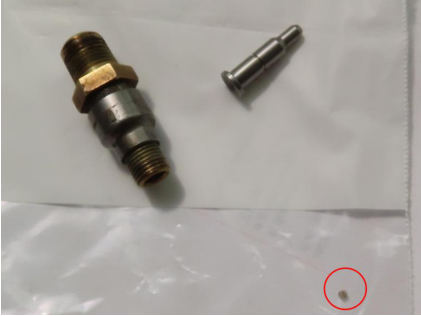 Photograph 4 – Debris Found in Fuel Injector Nozzle/Engine Cylinder No. 1, from the NTSB investigation of Piper Aircraft INC PA-28-181 accident near Addison, Texas, January 15, 2025