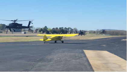 Photograph 4 – View of the three U.S. Army helicopters (two Boeing AH-64Es and one Sikorsky UH-60M) during the takeoff near N96963 Taylorcraft BC-12D, from the NTSB investigation of Taylorcraft BC12 accident near Russellville, Arkansas, March 22, 2025