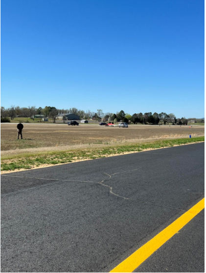 Photograph 6 – View of N39158 Taylorcraft BC-12D inverted on a grass field near the runway, from the NTSB investigation of Taylorcraft BC12 accident near Russellville, Arkansas, March 22, 2025