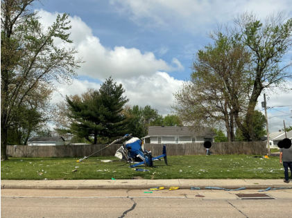 Photograph 12 – View of the accident site with the helicopter during the day, approximately facing to the west, from the NTSB investigation of Messerschmitt-Bolkow-Blohm BK 117 accident near Hartford, Illinois, April 25, 2025