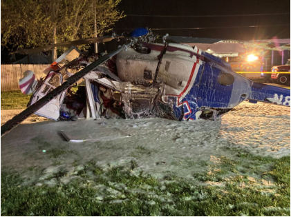 Photograph 5 – View of the left side of the helicopter at the accident site at night, from the NTSB investigation of Messerschmitt-Bolkow-Blohm BK 117 accident near Hartford, Illinois, April 25, 2025