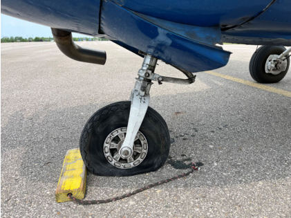 Photograph 2 – View of the nose landing gear, which sustained a flat tire, from the NTSB investigation of Cessna 182 accident near Charlevoix, Michigan, June 2, 2025