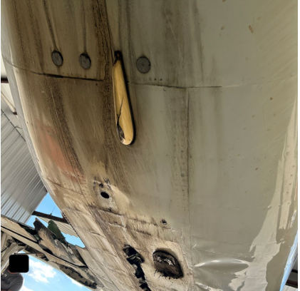 Photograph 3 – View of the underside of the fuselage inside of a hangar, from the NTSB investigation of Piper PA46 accident near Henderson, Texas, September 25, 2025