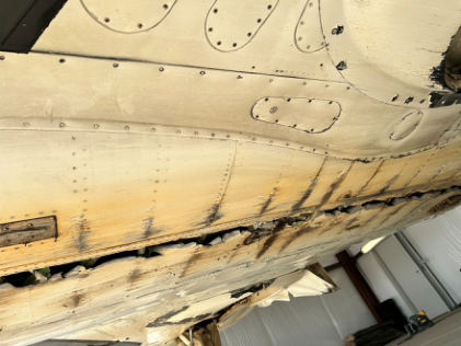 Photograph 4 – View of the underside of the fuselage inside of a hangar, from the NTSB investigation of Piper PA46 accident near Henderson, Texas, September 25, 2025