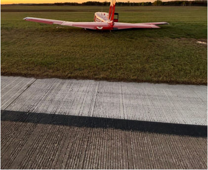 Photograph 1 – Accident airplane resting in grass, from the NTSB investigation of Piper PA-24-250 accident near Eau Claire, Wisconsin, October 19, 2025