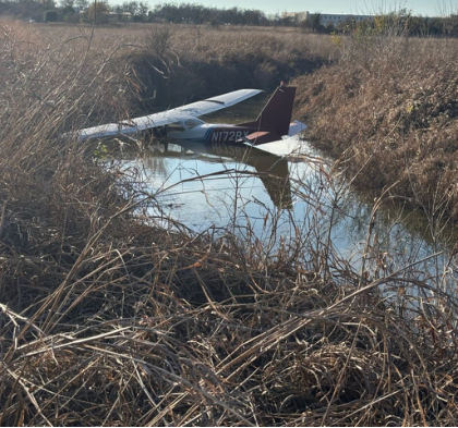 Photograph 2 – View of the left side of the airplane in the water, from the NTSB investigation of Cessna 172 accident near Taylor, Texas, December 26, 2025