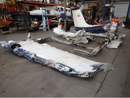 Photograph 4 – Left wing with leading edge, tip and root damage, damaged aileron and crushed flap., from the NTSB investigation of Cessna 182 accident near Rutherfordton, North Carolina, July 8, 2024