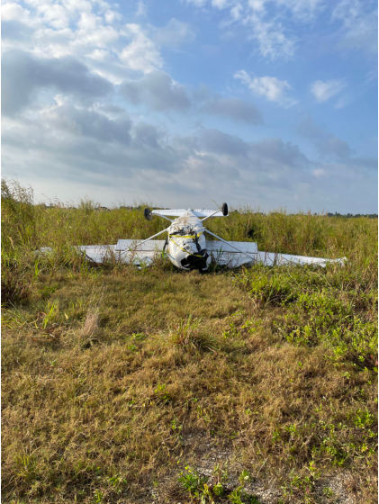 Photo 1 – Forward view of airplane upside down showing airframe buckling, from the NTSB investigation of Cessna 172 accident near Homestead, Florida, March 9, 2024