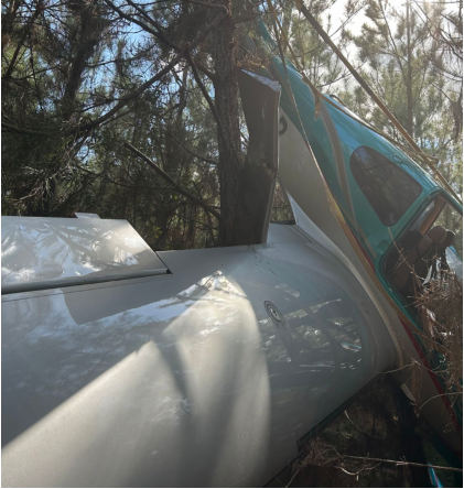 Photograph 2 – Airplane at the accident site suspended in trees., from the NTSB investigation of Cirrus Design CORP SR22 accident near Winokur, Georgia, March 16, 2024