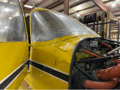 Photograph 4 – Right Forward Quartering View of the Forward Fuselage. Note the Extensive Skin Damage Aft of the Firewall, from the NTSB investigation of Piper PA-24-250 accident near North Kingstown, Rhode Island, March 30, 2024