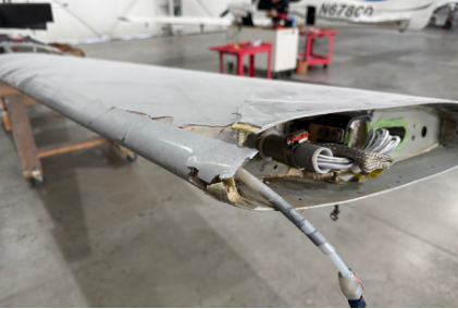 Photograph 5 - Digital Photograph From Repair Facility. View Depicting The Outer Portion of the Left Wing. Note the Damage along the Leading Edge and Also Chordwise, from the NTSB investigation of Cirrus Design CORP SR20 accident near Lagrangeville, New York, May 17, 2024