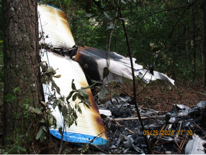 Photograph 1 – Empennage and wreckage at the site., from the NTSB investigation of Piper PA-28-151 accident near Hope Mills, North Carolina, May 26, 2024