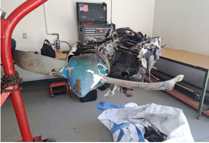 Photograph 5 – View of propeller assembly and engine on hoist. (NTSB), from the NTSB investigation of Piper PA-28-151 accident near Hope Mills, North Carolina, May 26, 2024