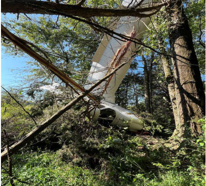 Photograph 1 – Airplane nose down resting inverted against a tree., from the NTSB investigation of Piper PA-28-181 accident near Somerville, New Jersey, September 4, 2024