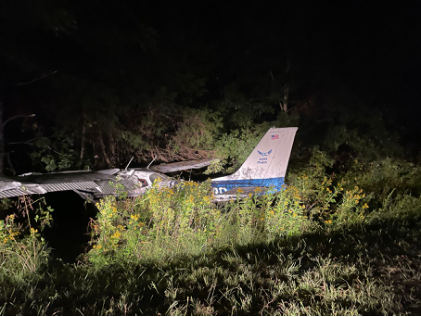 Photog rap h 1 – Vie w of airp lane in woode d are a showing d amag e d left wing . (Courte sy of FAA), from the NTSB investigation of Cessna 172K accident near Fredericksburg, Virginia, September 19, 2024