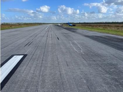 Photograph 3 – Runway damage and airplane at accident site, from the NTSB investigation of Piper PA28 accident near Palm Beach Gardens, Florida, November 13, 2024