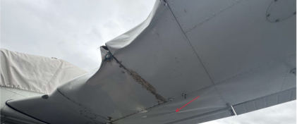 Photograph 2 – FAA Digital Photograph. View of the Bottom of a Portion of the Left Wing. Arrow Points to Buckling of the Lower Wing Skin Aft of the Main Spar, from the NTSB investigation of Piper PA28 accident near Knoxville, Tennessee, June 8, 2025