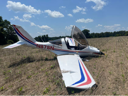 Photograph 1 – View of airplane with blue and red stripes in a field., from the NTSB investigation of Amateur-built TL-2000 accident near Dunavant, Virginia, June 20, 2025