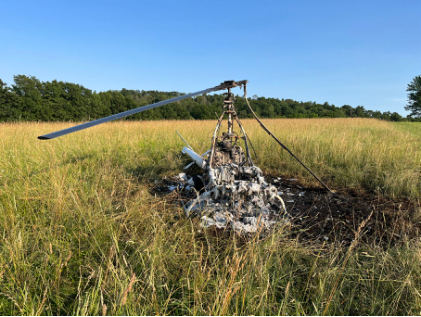 Photograph 1 – Forward view of upright post-crash fire damaged helicopter., from the NTSB investigation of Amateur-built ROTORWAY EXEC 162F accident near Towanda, Pennsylvania, July 4, 2025