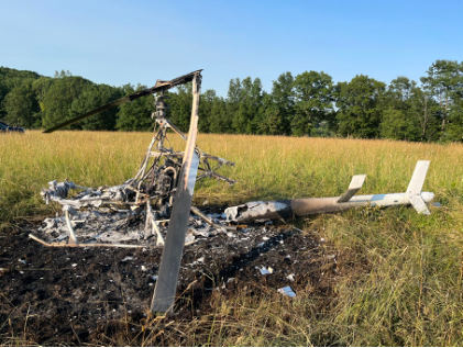 Photograph 4 – Left-side view of post-crash fire damaged helicopter., from the NTSB investigation of Amateur-built ROTORWAY EXEC 162F accident near Towanda, Pennsylvania, July 4, 2025