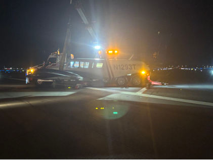 Photograph 4 – Left Side View of the Airplane Being Raised from the Runway, from the NTSB investigation of Piper PA34 accident near Fort Lauderdale, Florida, July 10, 2025