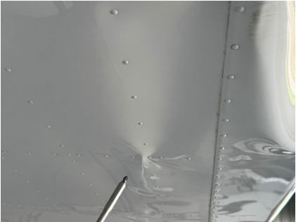 Photograph 5 – View of underside of right-hand wing showing buckling from spar damage, from the NTSB investigation of Cessna T182T accident near Venice, Florida, October 4, 2025