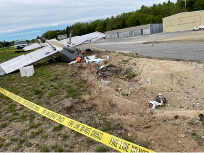 Photograph 1 – View from the nose showing impact point and inverted airplane, from the NTSB investigation of Amateur-built RV-7A accident near Jaffrey, New Hampshire, May 21, 2026