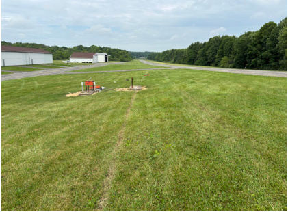 Photograph 5 – Left Main Landing Gear Grass Impression Toward VASI Light, from the NTSB investigation of Amateur-built LANCAIR ES accident near Youngstown, Ohio, June 8, 2026