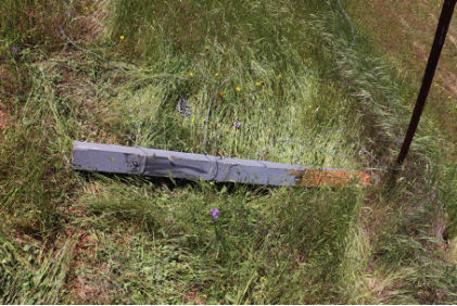 Photograph 4 – View of downed airport perimeter fence post with black transfer mark., from the NTSB investigation of Champion 7ECA accident near Cottonwood, California, April 29, 2025