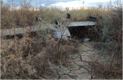 Photograph 1 – View of inverted airplane with substantial damage to the right wing, from the NTSB investigation of Amateur-built RV-7A accident near Gila Bend, Arizona, December 22, 2024