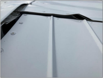 Photograph 4 – Left outboard wing upper surface damage., from the NTSB investigation of Cessna 170A accident near Everett, Washington, August 27, 2025