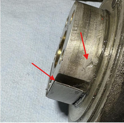 Photograph 5 – Tailwheel head, disassembled Arrows indicates gouges in outer bore, worn turn lock spring edges, from the NTSB investigation of Cessna 305 accident near Phoenix, Arizona, October 18, 2025
