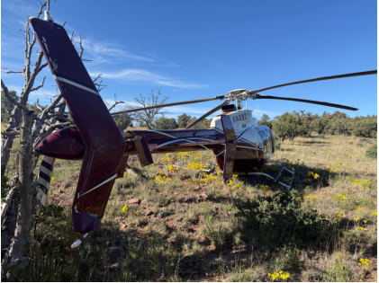 Photograph 2 – View from the left rear of the helicopter showing the tree and damage to the vertical stabilizer, from the NTSB investigation of Bell 407 accident near Young, Arizona, April 29, 2026